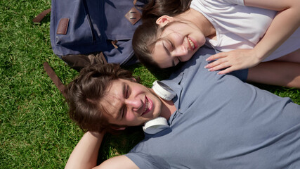Top view of romantic young couple resting on grass in park