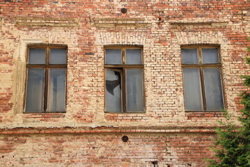 Fototapeta na wymiar Zerbrochene Fenster in einer alten Backsteinfassade in Görlitz
