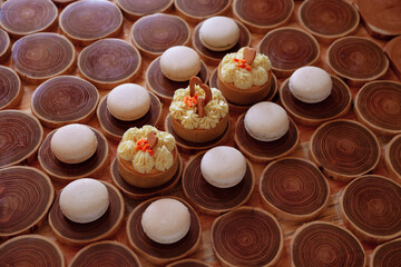 white delicate lowly macaroons on a wooden background. The pastel tone of the cream inside the French cookies