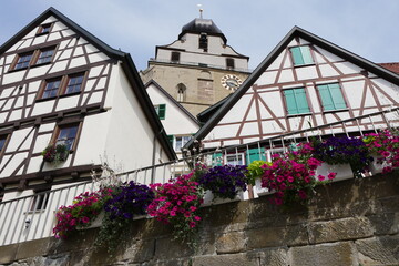 Fototapeta na wymiar Blühende Blumen, Fachwerkhäuser und Turm Stiftskirche in Herrenberg