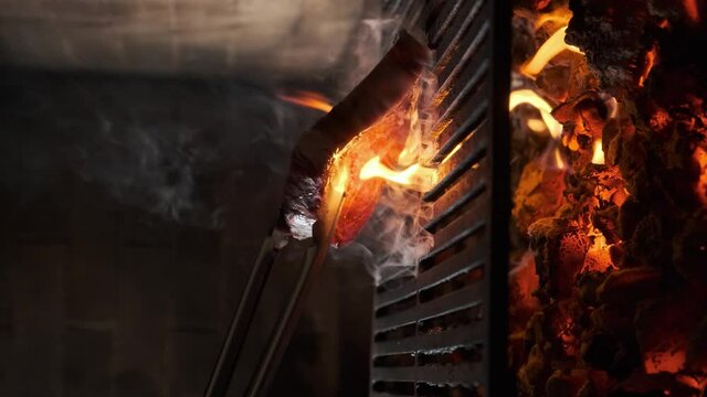 The chef prepares a steak on the grill with fire. Grilled raw steak.
Footage in 4K. Vertical video