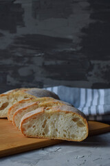 slices of delicious homemade sliced Italian ciabatta bread on a gray background . Close-up.vertical format. copy space