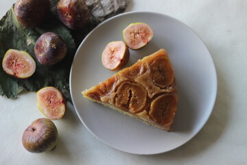 Slice of Fig upside down cake with lots of fresh figs and flavored with fresh orange juice. Shot on white background