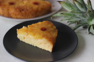 Slice of caramelised pineapple upside down cake. Home baked pineapple cake with pineapple slices are on the top