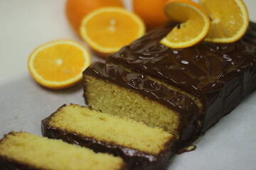 Orange loaf cake with Chocolate ganache. Decorated with slices of orange.
