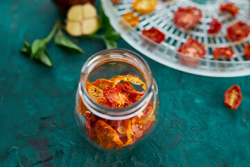 Homemade sun dried tomatoes with herbs, garlic in olive oil in a glass jar