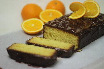 Orange loaf cake with Chocolate ganache. Decorated with slices of orange.
