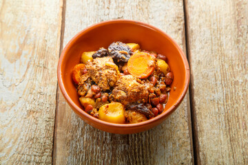 Jewish dish chelnt with meat on a wooden table in a plate. copy space