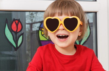 Happy smiling boy in sunglasses. Positive emotion in childhood