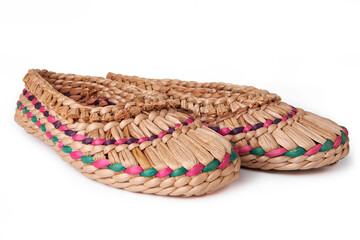 A pair of wicker bast shoes on a white background. Ethnic footwear