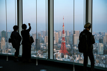 Tourists enjoying view of Tokyo city skyline from observation deck in Roppongi...