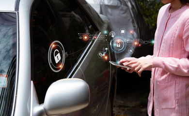 The woman holds a mobile phone and uses apps for the car owner's concept. She using a smartphone to check status, control her car