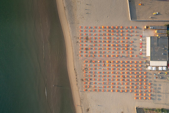 Birds view drone of the umbrellas and gazebos on Italian sandy beaches. Adriatic coast. Emilia Romagna region, Lido Adriano, Italy