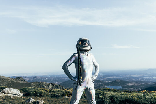 Confident spaceman standing in countryside