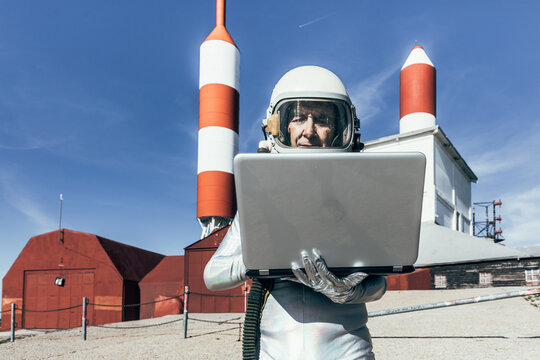 Cosmonaut using laptop near base