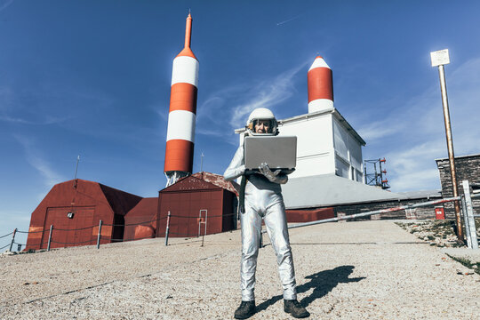 Cosmonaut using laptop near base