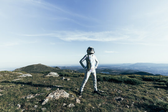 Confident spaceman standing in countryside