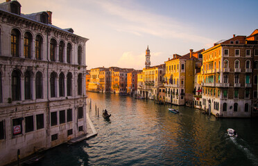 Naklejka premium Venice sunset with a gondola on the background of the canal and buildings