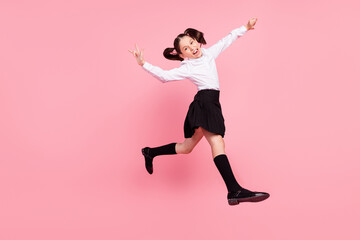 Fototapeta na wymiar Full length photo of crazy happy positive girl jump up show rock signs walk isolated on pink color background