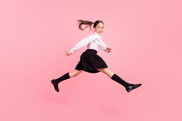 Fototapeta na wymiar Full body photo of young happy positive cheerful girl jump up run empty space isolated on pink color background