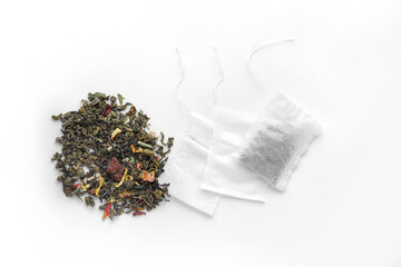 Tea bags with dry leaves on white background