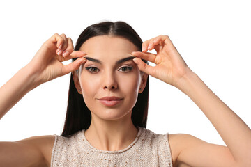 Young woman doing face building exercise against white background