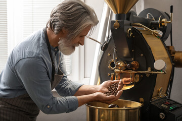 Senior man using modern coffee roaster