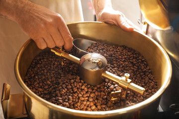 Senior man using modern coffee roaster, closeup