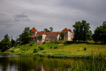Beautiful panorama of Svirzh castle by the river on a summer day, near Lviv.