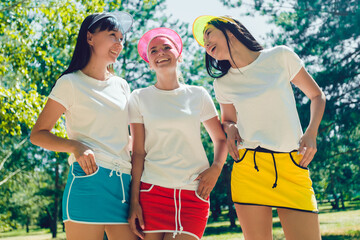 Three attractive girls in white T-shirts and bright sports skirts.