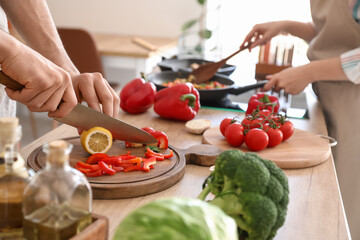 Young couple cooking in kitchen, closeup