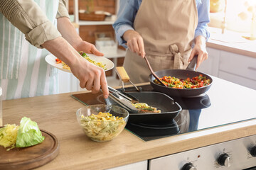 Young couple cooking in kitchen