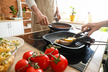 Woman cooking tasty fish in kitchen