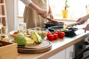 Fresh vegetables and pasta on table in kitchen