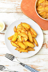 Composition with tasty baked potato on light wooden background