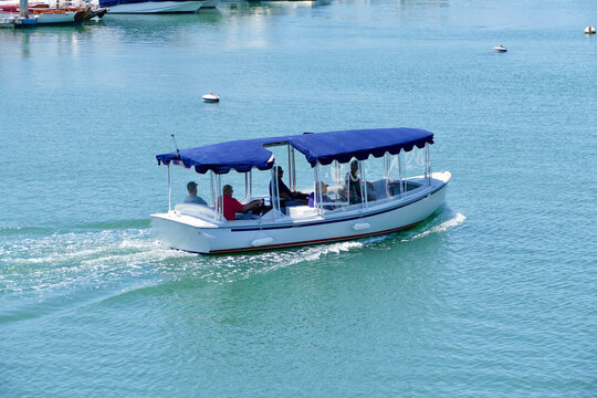 Group Of Men On A Harbor Cruise With An Electric Boat