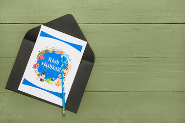 Obraz premium Greeting card for Rosh hashanah (Jewish New Year) with envelope on color wooden background