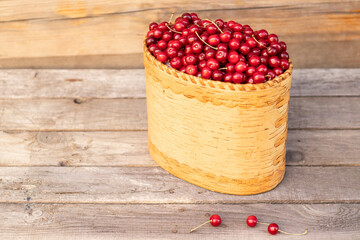 basket with ripe red cherry on a wooden background with copy space