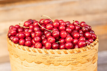 ripe sweet red cherry in a basket on a wooden background