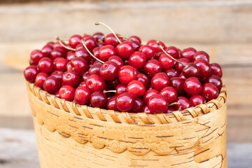 ripe sweet red cherry in a basket on a wooden background