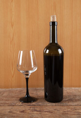 Bottle, glass and  wine on wooden background.