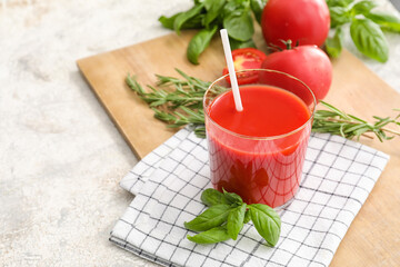 Glass of tasty tomato juice on table