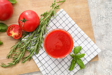 Glass of tasty tomato juice on table