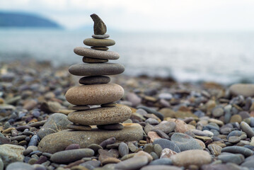 A pyramid of sea stones on the background of the sea.