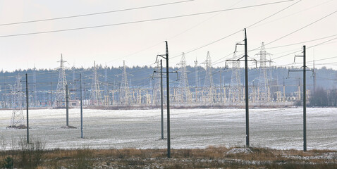 High voltage towers in winter with sky background.