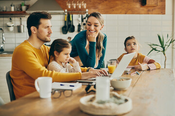 Happy woman enjoys while spending time with her husband and daughters at home.