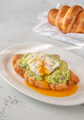 Croissant with guacamole and poached egg