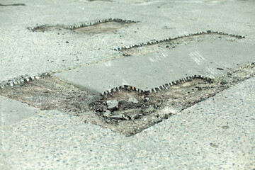 Road repair. Removing holes in the road. A cut piece of asphalt.