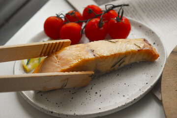 Salmon steak on white plate in restaurant