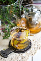 a cup of linden tea and glass teapot